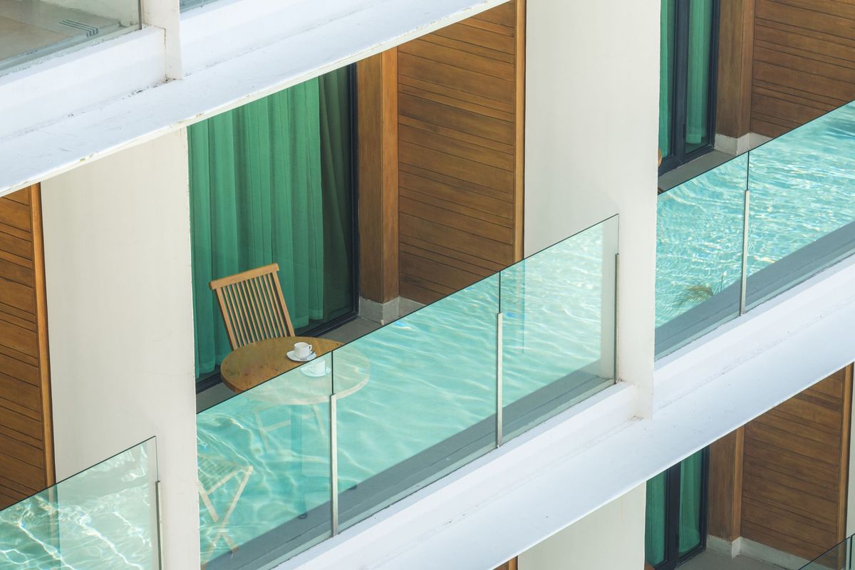 Frameless glass balustrades on stacked balconies with timber screens behind