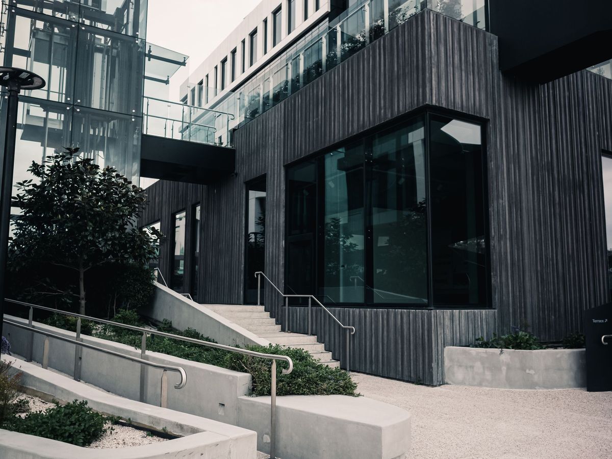 Large dark-framed windows set into a black-clad commercial building