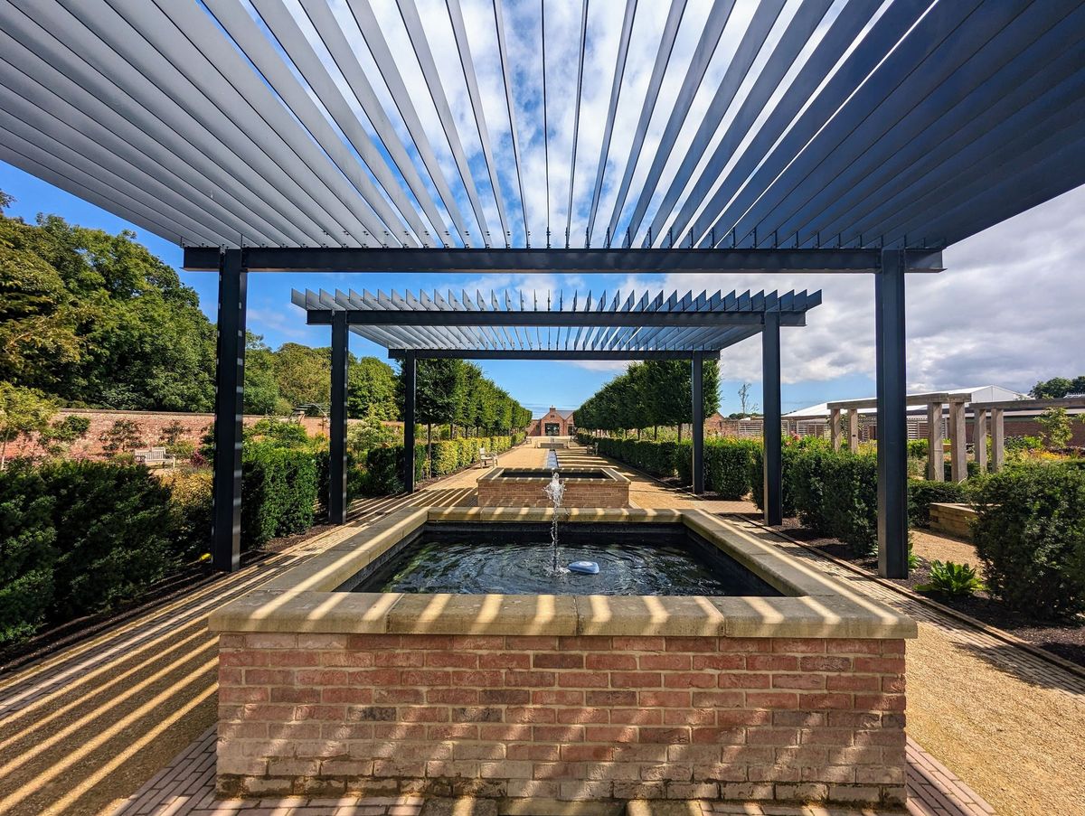 Louvred pergola over a garden with a water feature