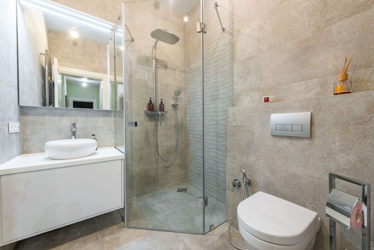 Frameless glass corner shower enclosure in a tiled bathroom